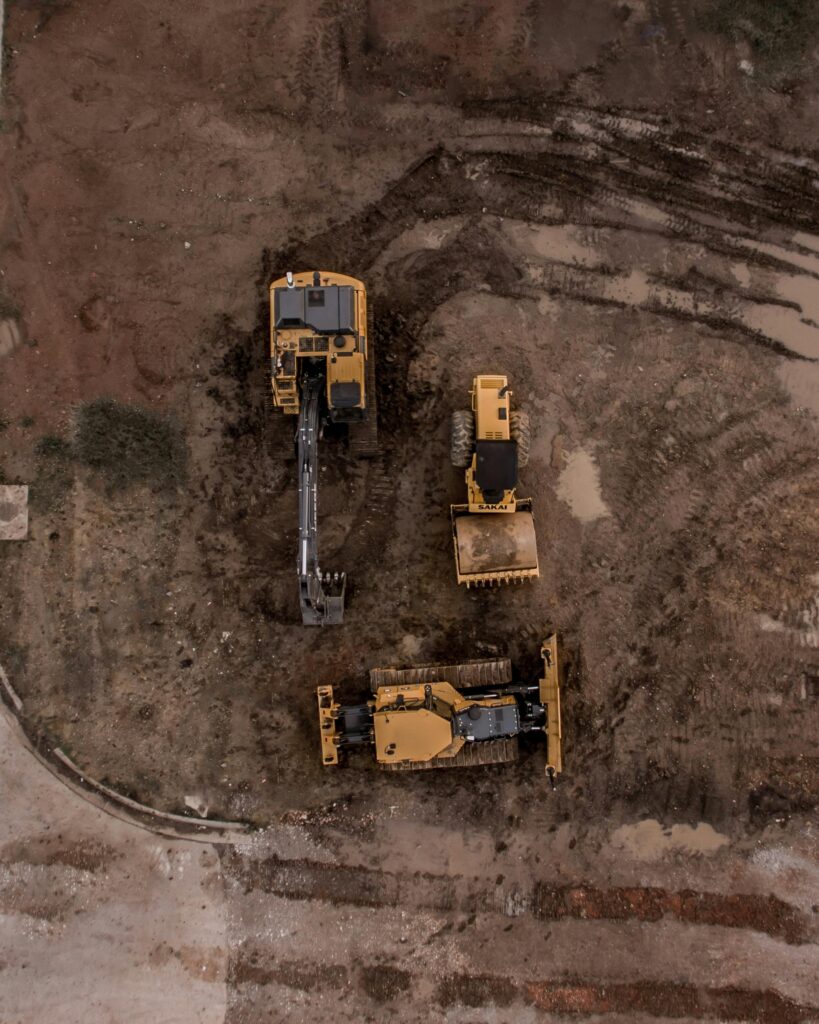 pexels-photo-1579356-1579356 An aerial shot of heavy machinery at a construction site, including excavators and road rollers.